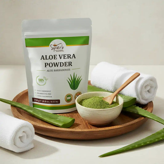 Spierb Aloe Vera Powder pouch beside a bowl of the green powder, a wooden spoon and fresh Aloe vera leaves